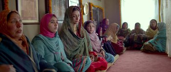 Movie still from “Haider” (2014), directed by Vishal Bhardwaj – A group of women sitting on the ground in front of a window; Medium shot, Low angle