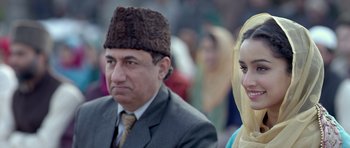 Movie still from “Haider” (2014), directed by Vishal Bhardwaj – A man and a woman wearing a hat and a suit; Close Up shot, Low angle