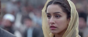 Movie still from “Haider” (2014), directed by Vishal Bhardwaj – A person wearing a yellow head scarf; Close Up shot, Over the shoulder angle