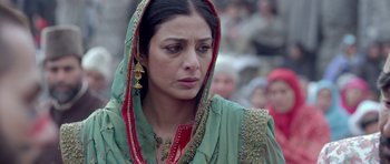 Movie still from “Haider” (2014), directed by Vishal Bhardwaj – A person wearing a green and red dress; Close Up shot, Over the shoulder angle