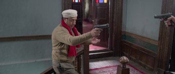 Movie still from “Haider” (2014), directed by Vishal Bhardwaj – An older man wearing a hat and holding a gun in his hand; Medium shot, Low angle