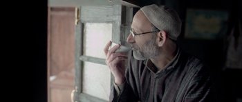 Movie still from “Haider” (2014), directed by Vishal Bhardwaj – An older man with a beard is talking on a cell phone; Close Up shot, Low angle