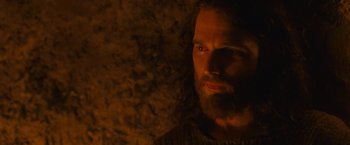 Movie still from “Hanna” (2011), directed by Joe Wright – A man with long hair and a goatee stares at the camera; Close Up shot, Over the shoulder angle