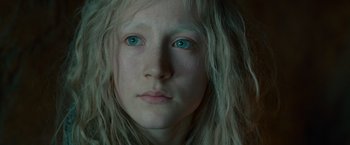 A person's face with green eyes