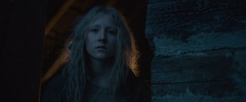 Movie still from “Hanna” (2011), directed by Joe Wright – A woman with long blonde hair standing next to a wall; Close Up shot, Low angle