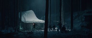 Movie still from “Hanna” (2011), directed by Joe Wright – A group of people sitting in the snow near a tent; Extreme Wide shot, Low angle