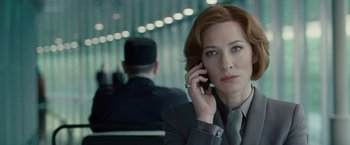 Movie still from “Hanna” (2011), directed by Joe Wright – A woman in a suit and tie talking on a cell phone; Close Up shot, Over the shoulder angle
