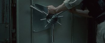 Movie still from “Hanna” (2011), directed by Joe Wright – A hand is holding a bunch of metal bars; Extreme Close Up shot, High angle