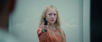 Movie still from “Hanna” (2011), directed by Joe Wright – A young girl holding a gun in her hand; Close Up shot, High angle