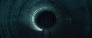 Movie still from “Hanna” (2011), directed by Joe Wright – A dark tunnel with stairs going up to it; Extreme Wide shot, Overhead angle