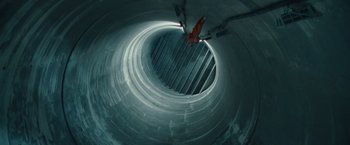 Movie still from “Hanna” (2011), directed by Joe Wright – A person is hanging upside down inside a tunnel; Extreme Wide shot, Overhead angle