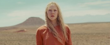 Movie still from “Hanna” (2011), directed by Joe Wright – A woman with long blonde hair standing in a field; Medium shot, Low angle