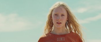 Movie still from “Hanna” (2011), directed by Joe Wright – A young girl with long blonde hair wearing an orange t - shirt; Close Up shot, Low angle