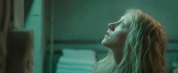 Movie still from “Hanna” (2011), directed by Joe Wright – A woman looking up into the air with her eyes closed; Close Up shot, Low angle