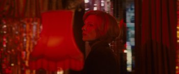 Movie still from “Hanna” (2011), directed by Joe Wright – A woman with red hair is standing in the dark; Close Up shot, Over the shoulder angle