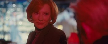 Movie still from “Hanna” (2011), directed by Joe Wright – A woman with red hair is smiling for the camera; Close Up shot, Over the shoulder angle