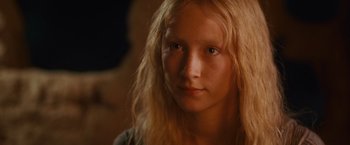 Movie still from “Hanna” (2011), directed by Joe Wright – A young girl with blonde hair is looking at the camera; Close Up shot, Over the shoulder angle