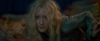 Movie still from “Hanna” (2011), directed by Joe Wright – A woman with blonde hair and green eyes looking at the camera; Close Up shot, Low angle
