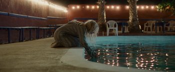 Movie still from “Hanna” (2011), directed by Joe Wright – A woman kneeling down by a pool of water; Wide shot, High angle