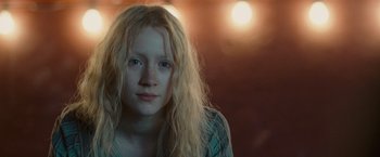 Movie still from “Hanna” (2011), directed by Joe Wright – A woman with long blonde hair is looking at the camera; Close Up shot, Low angle