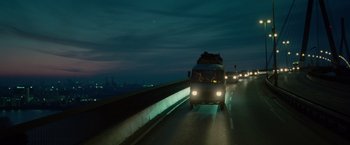 Movie still from “Hanna” (2011), directed by Joe Wright – A bus driving down a highway at night; Extreme Wide shot, Low angle