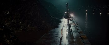 Movie still from “Hanna” (2011), directed by Joe Wright – A light house on the side of the road at night; Extreme Wide shot, High angle