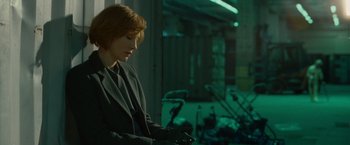 Movie still from “Hanna” (2011), directed by Joe Wright – A woman in a suit looking down at her cell phone; Medium shot, High angle