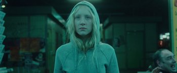 Movie still from “Hanna” (2011), directed by Joe Wright – A young girl with blonde hair wearing a hooded sweatshirt; Close Up shot, Low angle