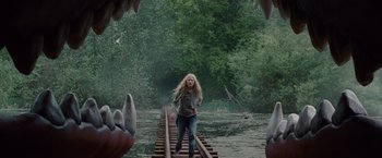 Movie still from “Hanna” (2011), directed by Joe Wright – A woman walking across a bridge in the middle of a forest; Wide shot, Over the shoulder angle
