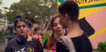 Movie still from “Heartbreak High” (2022), created by Michael Jenkins – A woman standing next to a man in a crowd; Close Up shot, Over the shoulder angle