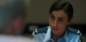 Movie still from “Heartbreak High” (2022), created by Michael Jenkins – A woman in a uniform is sitting in front of a camera; Close Up shot, Over the shoulder angle