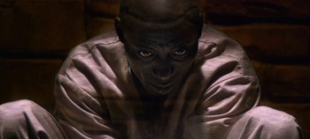 Movie still from “Black Mirror” (2011), created by Charlie Brooker – A man with a bald head is looking at the camera; Close Up shot, High angle