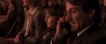 Movie still from “Hook” (1991), directed by Steven Spielberg – A man and a woman sitting in front of a cell phone; Close Up shot, Low angle