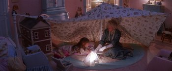 Movie still from “Hook” (1991), directed by Steven Spielberg – A woman and a girl sitting on the floor under a blanket; Wide shot, High angle