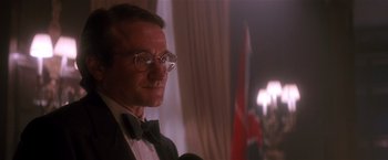 Movie still from “Hook” (1991), directed by Steven Spielberg – A man in a suit and bow tie with a microphone in front of him; Close Up shot, Low angle