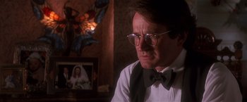 Movie still from “Hook” (1991), directed by Steven Spielberg – A person wearing glasses and a bow tie; Close Up shot, Over the shoulder angle