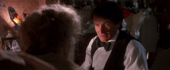 Movie still from “Hook” (1991), directed by Steven Spielberg – A person wearing a suit and a bow tie; Close Up shot, Over the shoulder angle