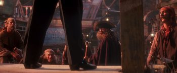 Movie still from “Hook” (1991), directed by Steven Spielberg – A man with a beard and a pirate hat on; Medium shot, Over the shoulder angle