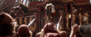 Movie still from “Hook” (1991), directed by Steven Spielberg – A man dressed as a pirate holding a sword in front of a group of people; Wide shot, Over the shoulder angle