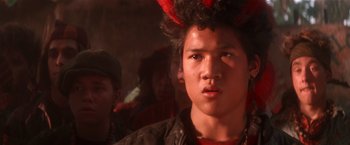Movie still from “Hook” (1991), directed by Steven Spielberg – A young man wearing a red and black jacket; Close Up shot, Over the shoulder angle