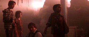 Movie still from “Hook” (1991), directed by Steven Spielberg – A man standing next to a child in a dark room; Medium shot, Low angle