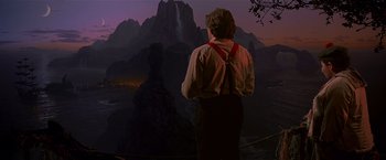 Movie still from “Hook” (1991), directed by Steven Spielberg – A man standing in front of a mountain at night; Wide shot, Over the shoulder angle