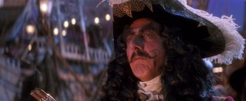 Movie still from “Hook” (1991), directed by Steven Spielberg – A person wearing a pirate costume; Close Up shot, Low angle