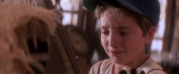 Movie still from “Hook” (1991), directed by Steven Spielberg – A young boy with a baseball cap is crying; Close Up shot, Over the shoulder angle