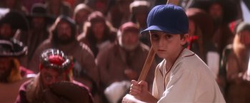 Movie still from “Hook” (1991), directed by Steven Spielberg – A young boy holding a baseball bat in front of a crowd; Close Up shot, High angle