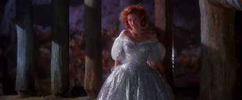 Movie still from “Hook” (1991), directed by Steven Spielberg – A red headed woman in a silver dress; Medium shot, Low angle