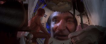 Movie still from “Hook” (1991), directed by Steven Spielberg – A woman sitting in front of a clock with an image of a man's face in the background; Extreme Close Up shot, Over the shoulder angle