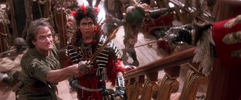 Movie still from “Hook” (1991), directed by Steven Spielberg – A man dressed as a pirate holding a sword; Medium shot, High angle