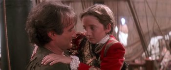 Movie still from “Hook” (1991), directed by Steven Spielberg – A man and a young girl in medieval garb looking at each other; Close Up shot, Over the shoulder angle