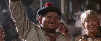 Movie still from “Hook” (1991), directed by Steven Spielberg – A young boy wearing a hat and holding a microphone; Close Up shot, Low angle